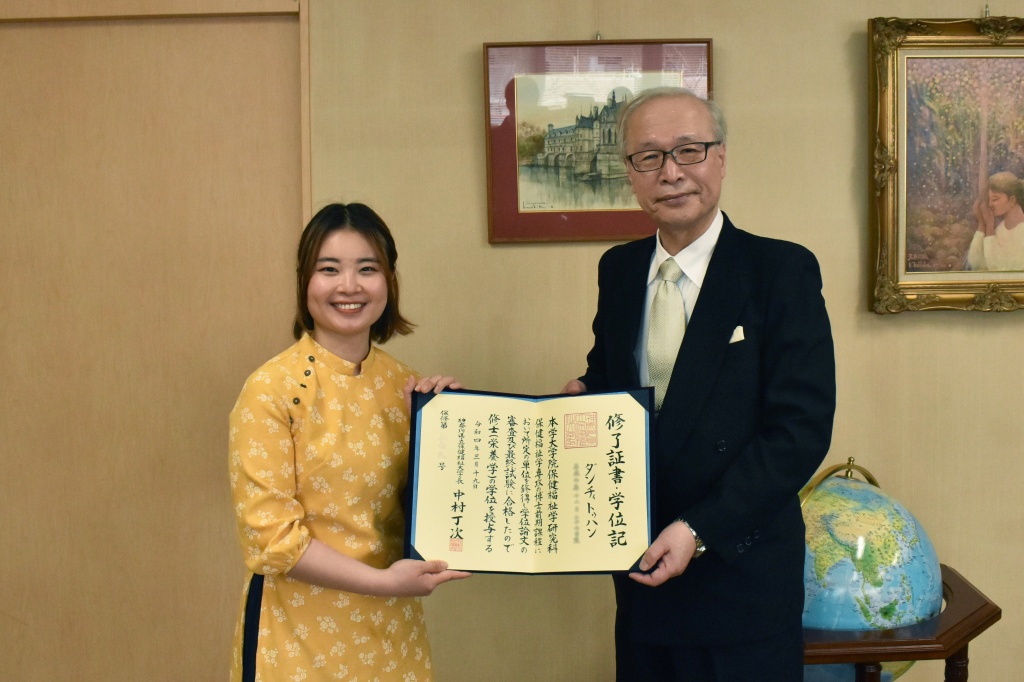 修了をむかえ、中村学長と記念撮影するHangさん